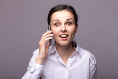 beyaz gömlekli kız telefonda iletişim kuruyor