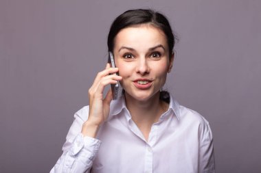 beyaz gömlekli kız telefonda iletişim kuruyor