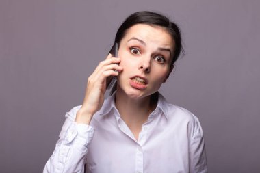 beyaz gömlekli kız telefonda iletişim kuruyor