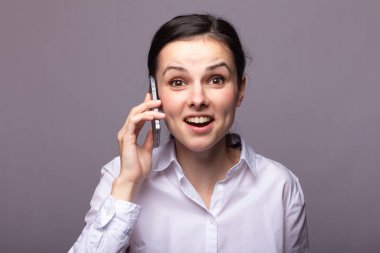 beyaz gömlekli kız telefonda iletişim kuruyor