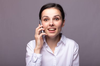 beyaz gömlekli kız telefonda iletişim kuruyor