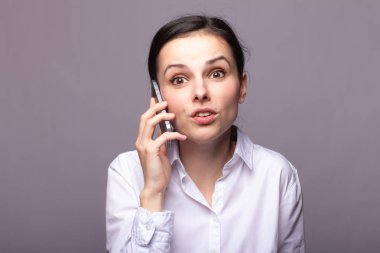 beyaz gömlekli kız telefonda iletişim kuruyor