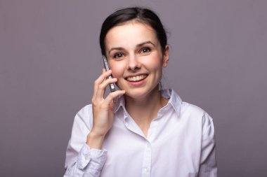 beyaz gömlekli kız telefonda iletişim kuruyor