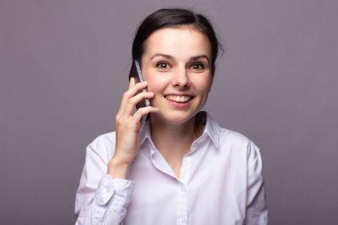 beyaz gömlekli kız telefonda iletişim kuruyor