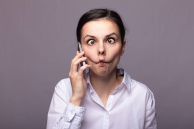 beyaz gömlekli kız telefonda iletişim kuruyor