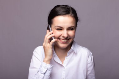 beyaz gömlekli kız telefonda iletişim kuruyor
