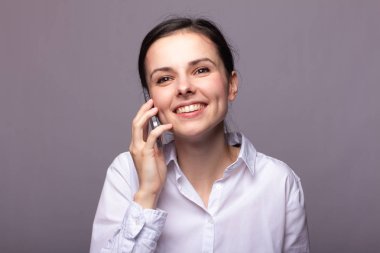 beyaz gömlekli kız telefonda iletişim kuruyor