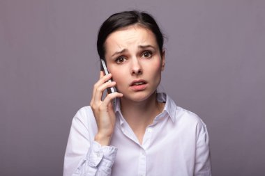 beyaz gömlekli kız telefonda iletişim kuruyor