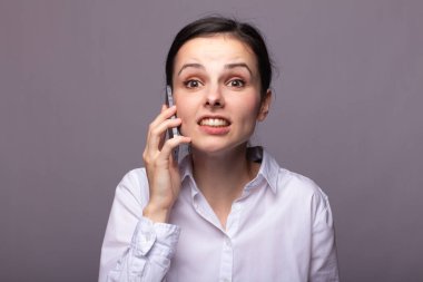 beyaz gömlekli kız telefonda iletişim kuruyor
