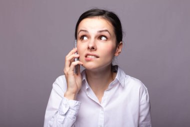 beyaz gömlekli kız telefonda iletişim kuruyor