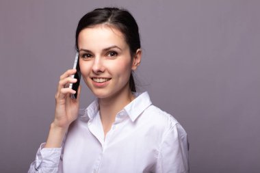 beyaz gömlekli kız telefonda iletişim kuruyor