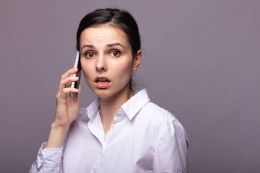 beyaz gömlekli kız telefonda iletişim kuruyor