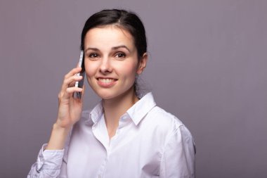 beyaz gömlekli kız telefonda iletişim kuruyor