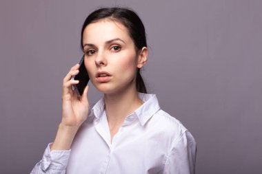 beyaz gömlekli kız telefonda iletişim kuruyor