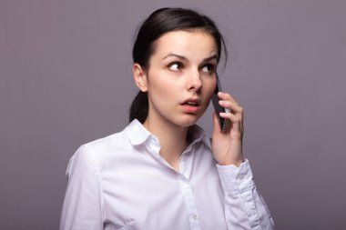 beyaz gömlekli kız telefonda iletişim kuruyor