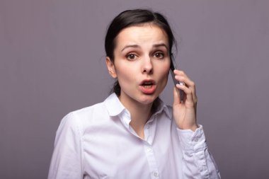 beyaz gömlekli kız telefonda iletişim kuruyor