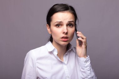 beyaz gömlekli kız telefonda iletişim kuruyor