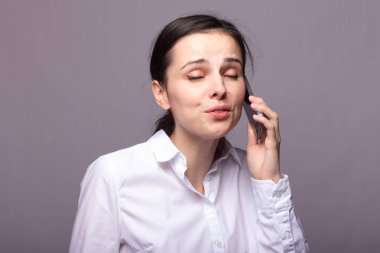 beyaz gömlekli kız telefonda iletişim kuruyor