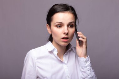 beyaz gömlekli kız telefonda iletişim kuruyor