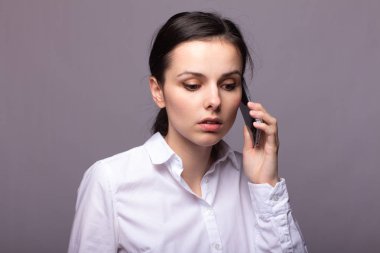 beyaz gömlekli kız telefonda iletişim kuruyor