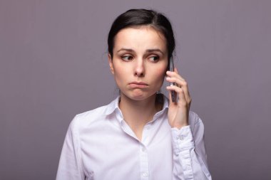 beyaz gömlekli kız telefonda iletişim kuruyor