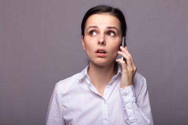 beyaz gömlekli kız telefonda iletişim kuruyor