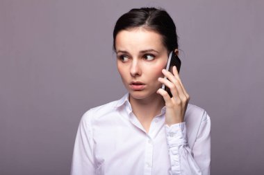 beyaz gömlekli kız telefonda iletişim kuruyor