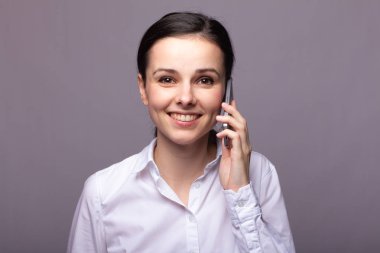 beyaz gömlekli kız telefonda iletişim kuruyor