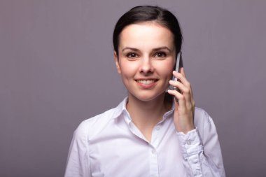 beyaz gömlekli kız telefonda iletişim kuruyor