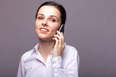 beyaz gömlekli kız telefonda iletişim kuruyor