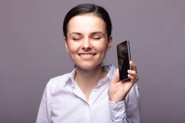 beyaz gömlekli kız telefonda iletişim kuruyor