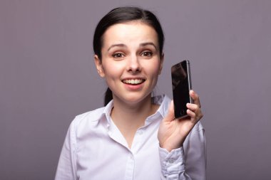 beyaz gömlekli kız telefonda iletişim kuruyor