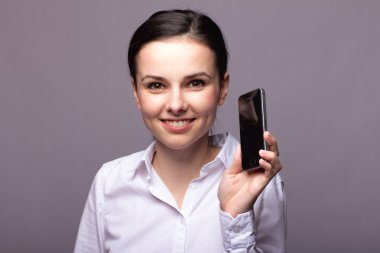 beyaz gömlekli kız telefonda iletişim kuruyor