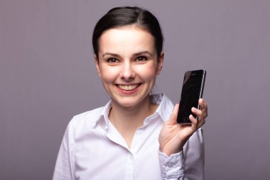 beyaz gömlekli kız telefonda iletişim kuruyor
