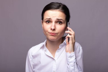 beyaz gömlekli kız telefonda iletişim kuruyor