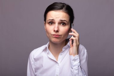 beyaz gömlekli kız telefonda iletişim kuruyor