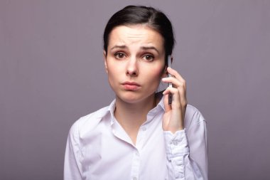 beyaz gömlekli kız telefonda iletişim kuruyor