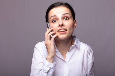 beyaz gömlekli kız telefonda iletişim kuruyor
