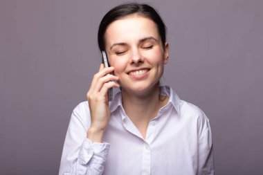 beyaz gömlekli kız telefonda iletişim kuruyor