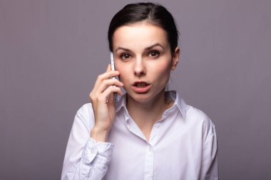 beyaz gömlekli kız telefonda iletişim kuruyor