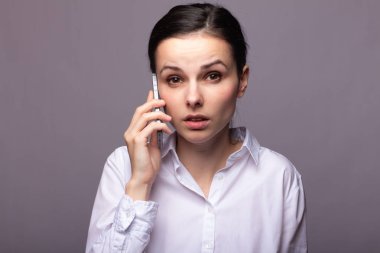 beyaz gömlekli kız telefonda iletişim kuruyor