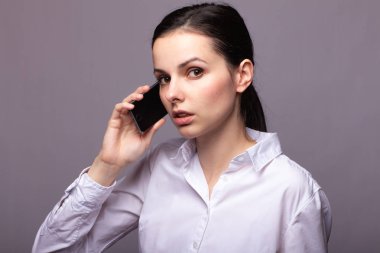 beyaz gömlekli kız telefonda iletişim kuruyor