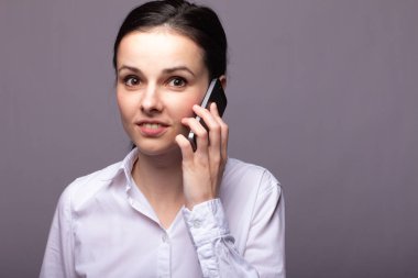 beyaz gömlekli kız telefonda iletişim kuruyor