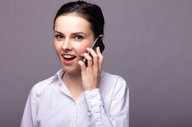 beyaz gömlekli kız telefonda iletişim kuruyor