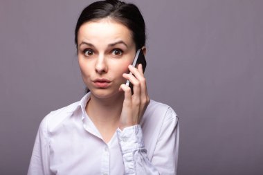 beyaz gömlekli kız telefonda iletişim kuruyor