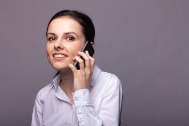 beyaz gömlekli kız telefonda iletişim kuruyor