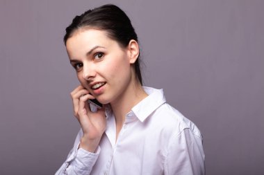 beyaz gömlekli kız telefonda iletişim kuruyor