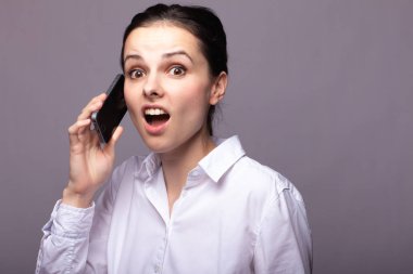 beyaz gömlekli kız telefonda iletişim kuruyor