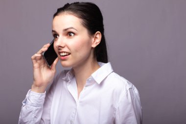 beyaz gömlekli kız telefonda iletişim kuruyor