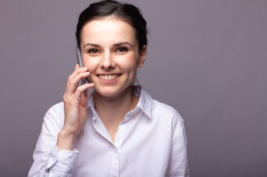 beyaz gömlekli kız telefonda iletişim kuruyor